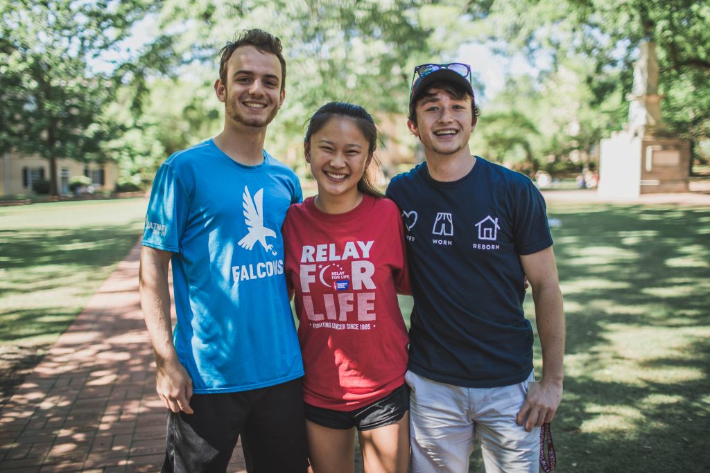 Three students smiling at a college campus