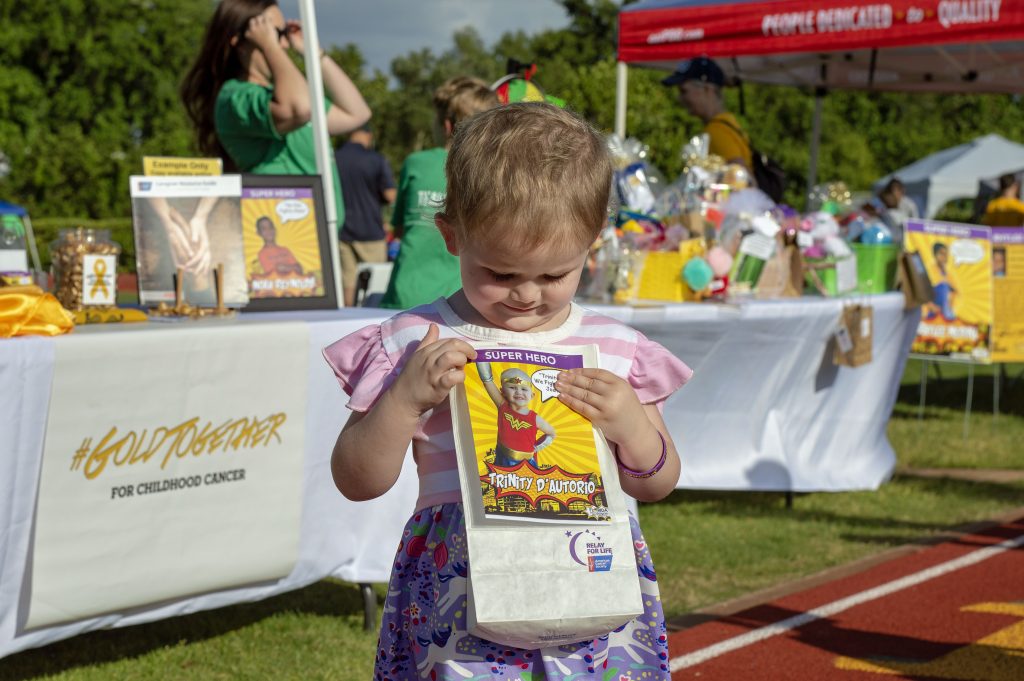 Childhood holding Luminaria bag at Gold Together/Relay For Life event